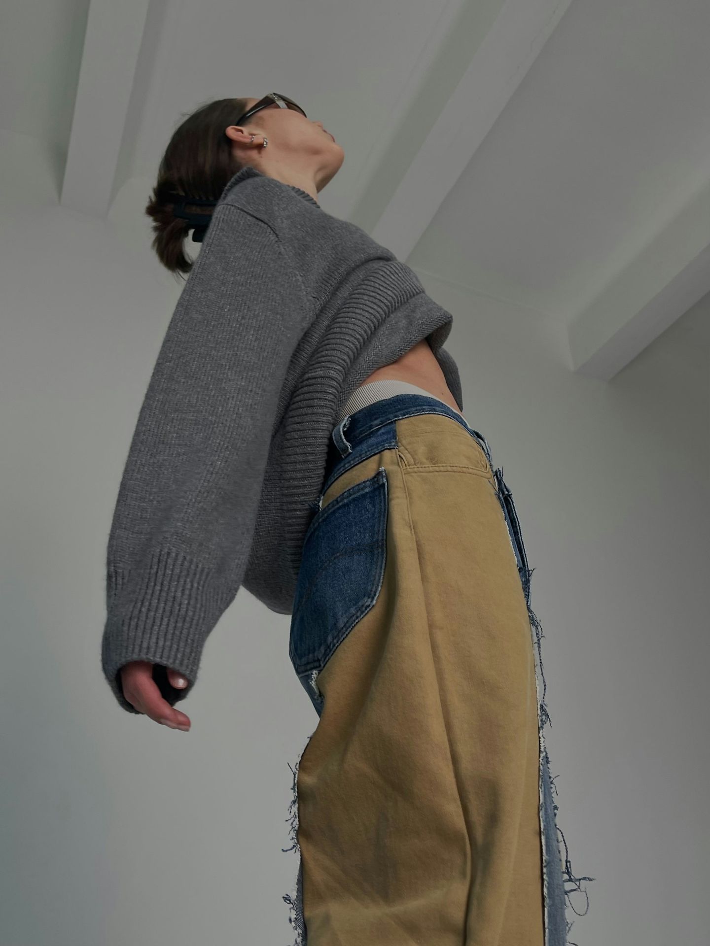 A woman in a sweater and unique pants.